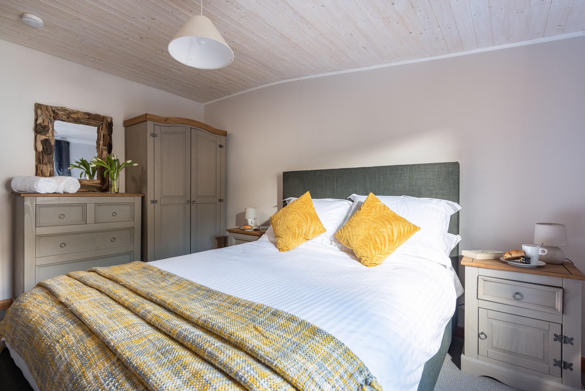 Welcoming shades of grey and yellow invite you to unwind in the master bedroom. 