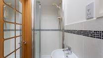The convenient en suite shower room features a walk-in shower. 