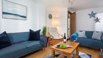 Blue hues and coastal decor encourage a calm and relaxing atmosphere in the sitting room. 