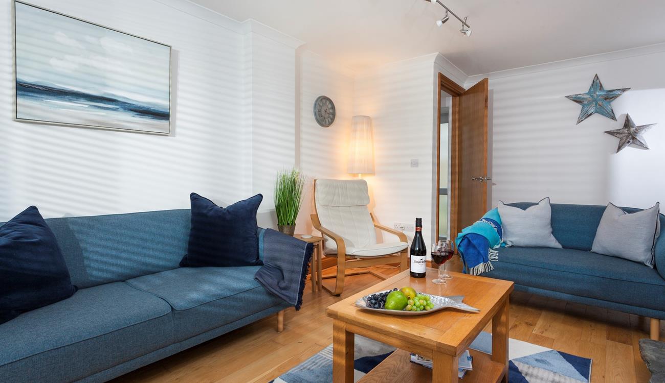 Blue hues and coastal decor encourage a calm and relaxing atmosphere in the sitting room. 