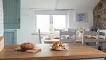 With its stable door, exposed granite wall, farmhouse-style table and slanted roof, the dining room exudes character and charm.