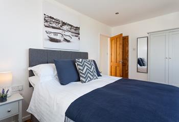 Calming blues, whites and greys create a relaxing space in this king size room. 