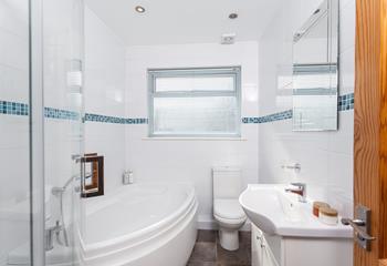 Beautifully finished, the bright bathroom features a large bath and a separate shower. 