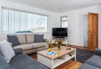 Bright and modern, the living room is filled with natural light flowing in through the large window. 