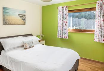Bright pops of colour and minimalistic decor ensure the main bedroom has a stylish and uncluttered feel.