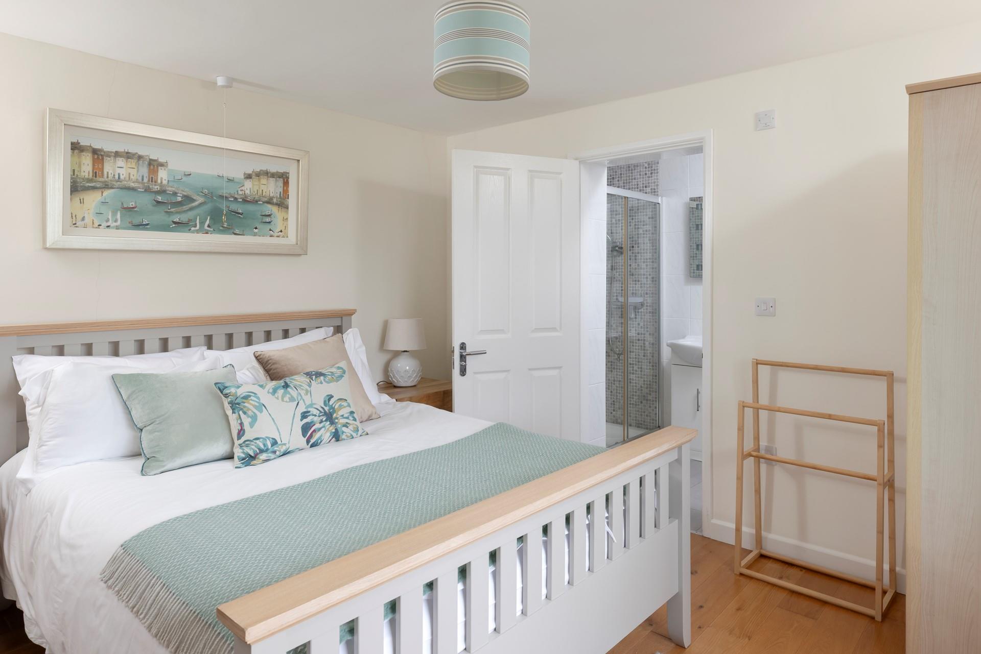 Bedroom 1 has a spacious king size bed and stylish furnishings, perfect for a relaxing night's slumber.