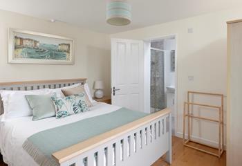 Bedroom 1 has a spacious king size bed and stylish furnishings, perfect for a relaxing night's slumber.