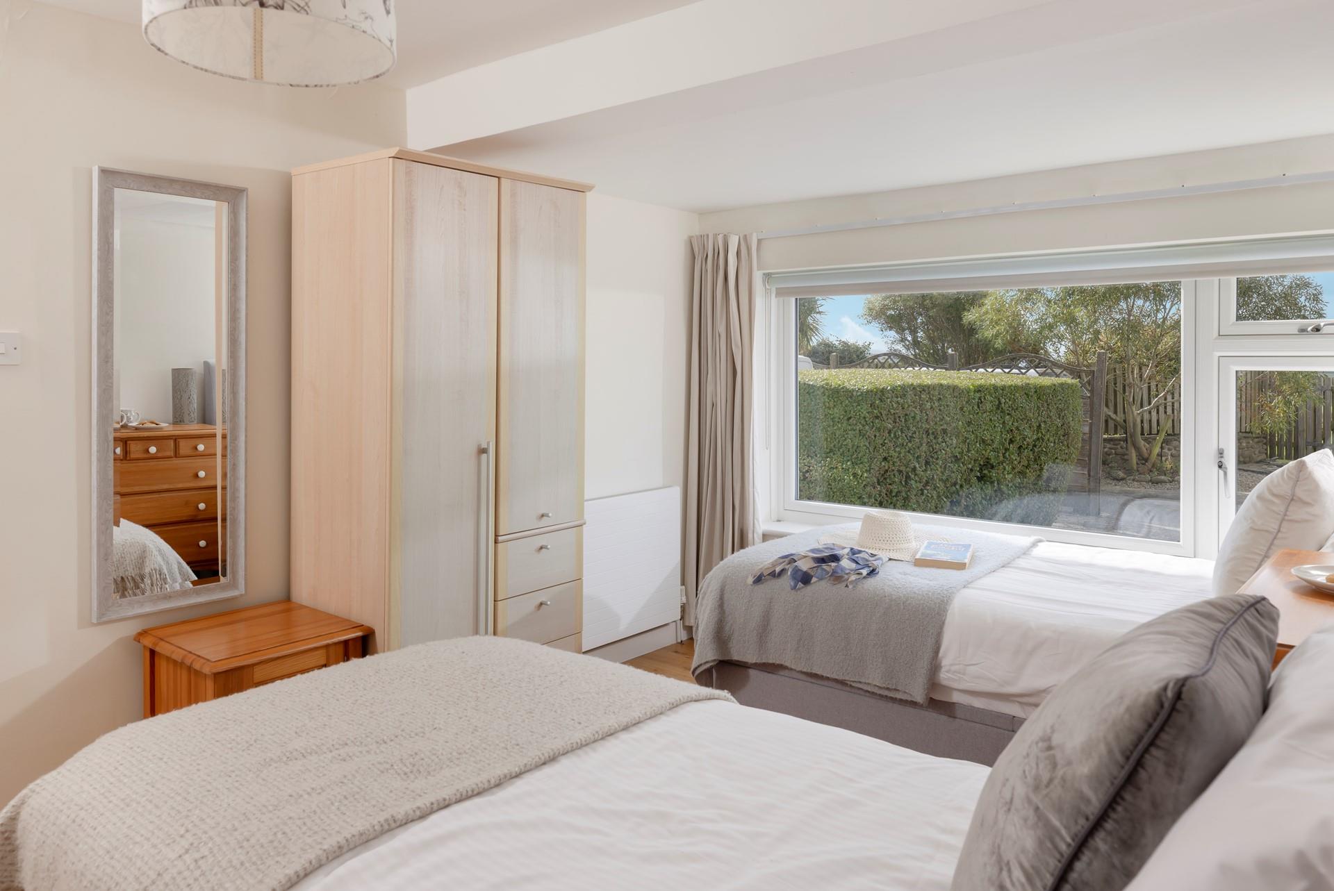 The twin bedroom is decorated with neutral grey tones and creates a calming space to relax.