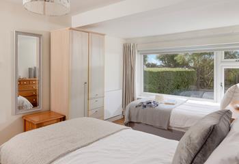 The twin bedroom is decorated with neutral grey tones and creates a calming space to relax.