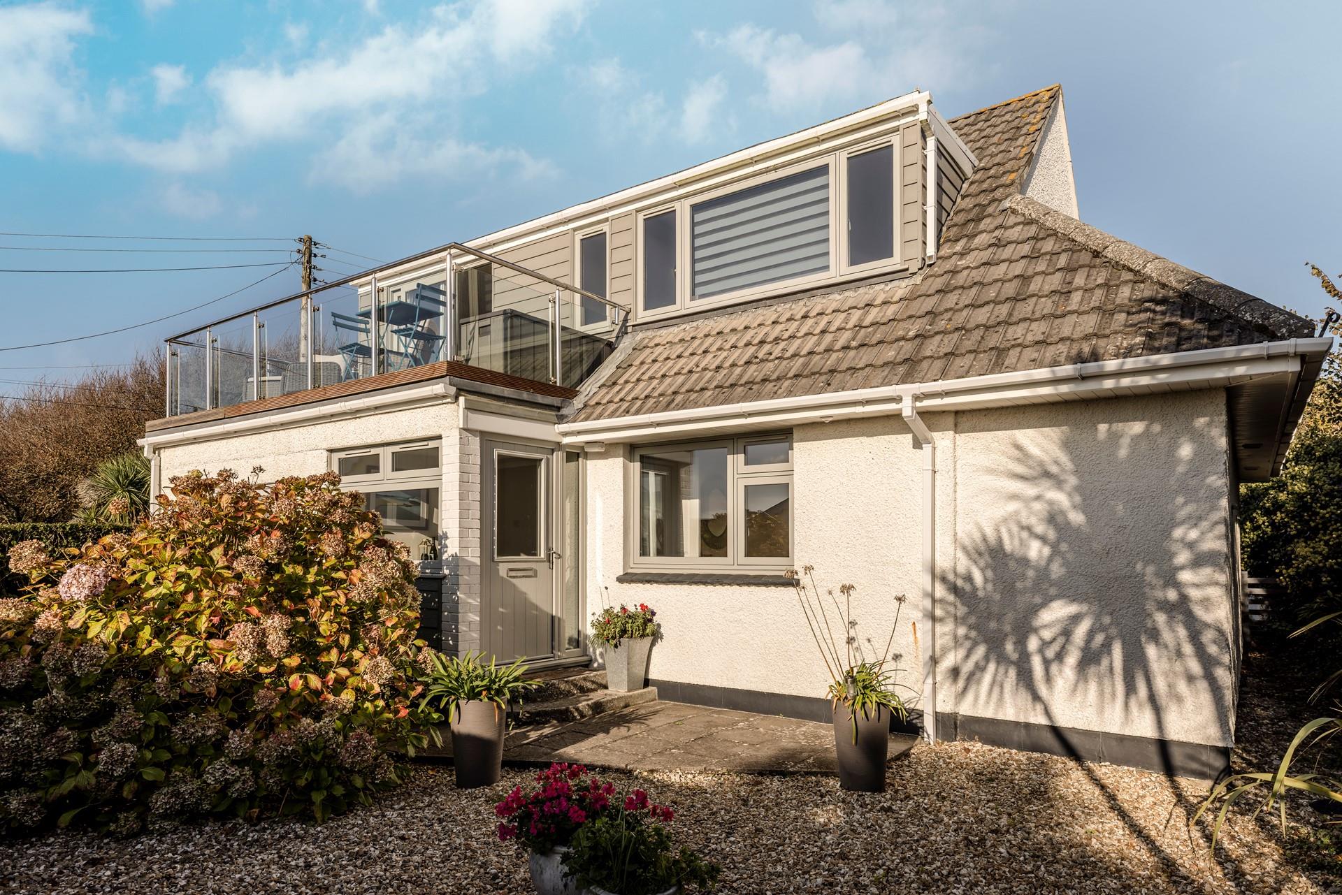 Lovely secluded gravel area outside the front door entrance, with glass balustrade balcony above to take full advantage of the views.
