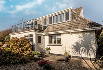 Lovely secluded gravel area outside the front door entrance, with glass balustrade balcony above to take full advantage of the views.