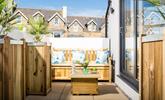 Unwind on the patio, a lovely sheltered area for sitting in the sun. - Thumbnail Image