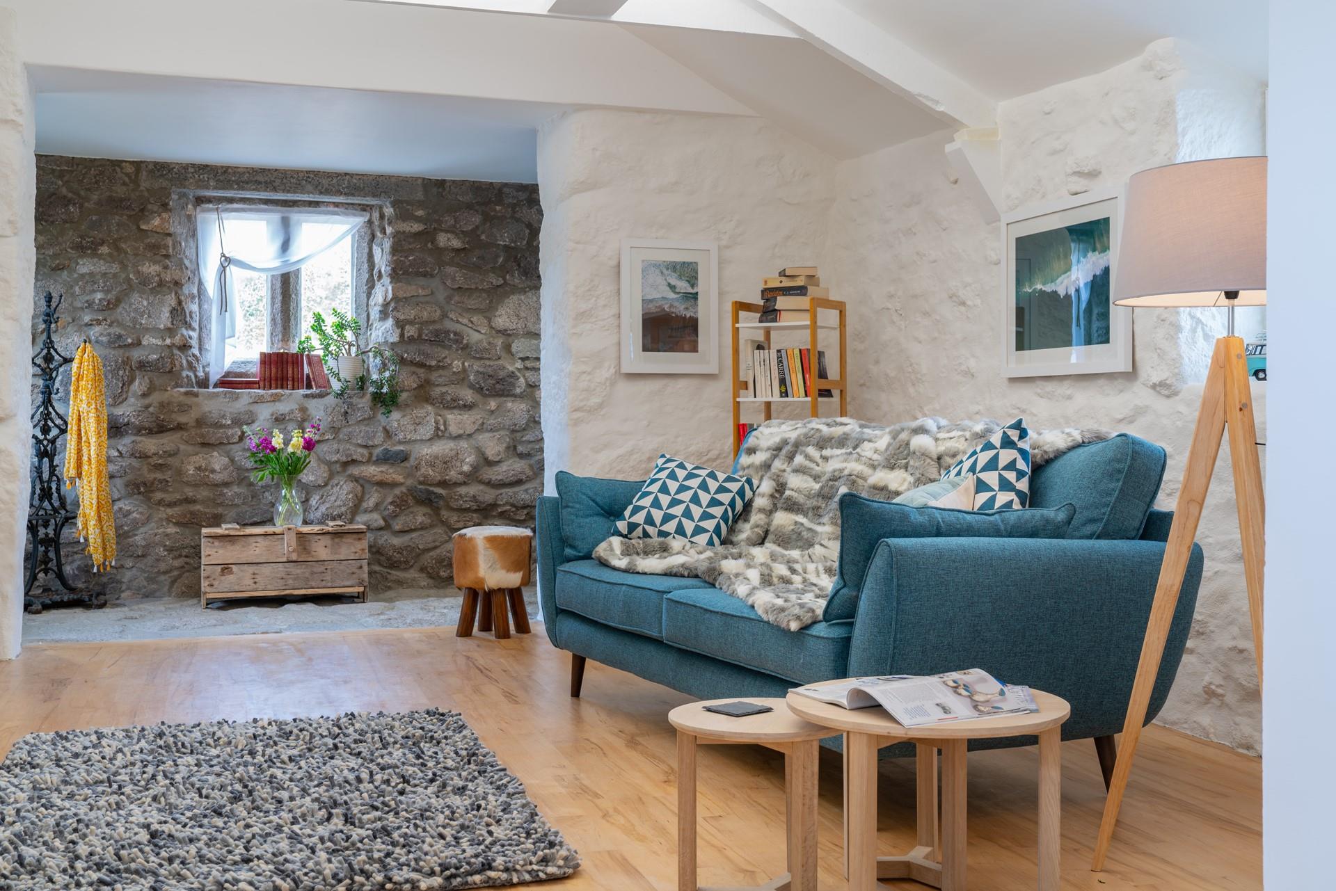 Exposed stone walls and wooden beams contribute to the natural Cornish interior.