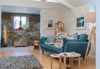 Exposed stone walls and wooden beams contribute to the natural Cornish interior.