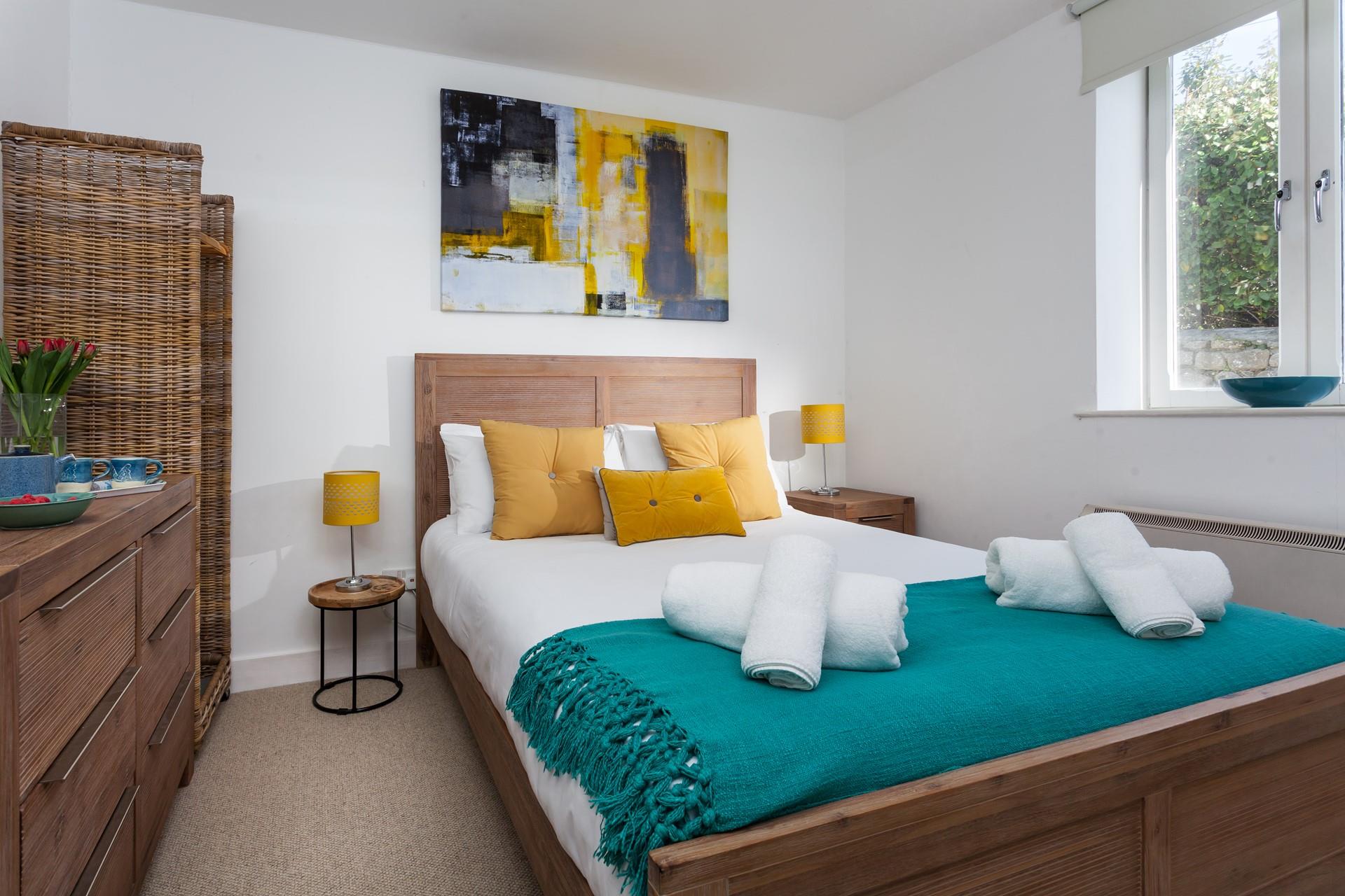 The bedroom is tastefully decorated in hues of teal and yellow.