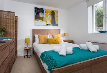 The bedroom is tastefully decorated in hues of teal and yellow.