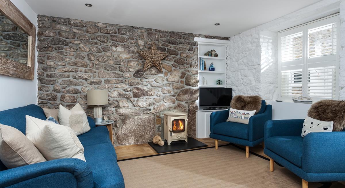 The living space has a stone-faced accent wall with natural oak wood flooring and a TV and shelving unit, creating a cosy space for all.