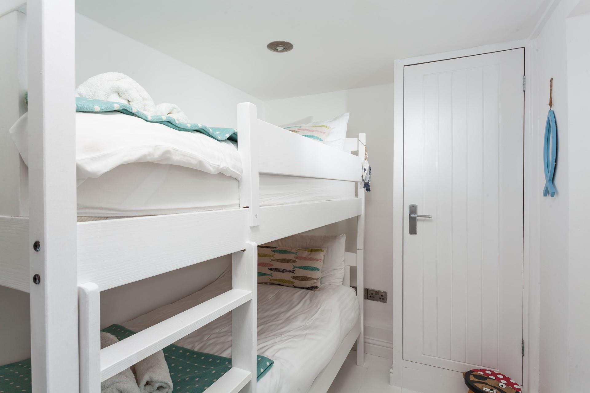 Bedroom 2 has painted wood bunk beds perfect for the little ones.