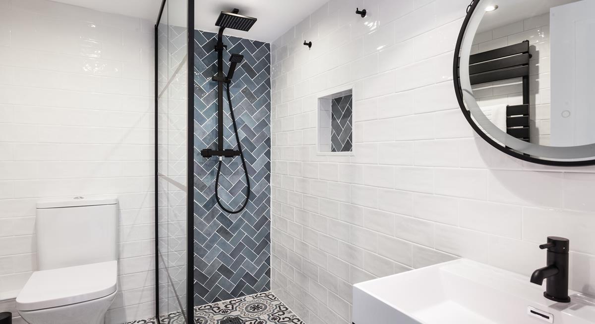 The family bathroom is decorated to a high standard with contemporary tiling and a rainfall shower.