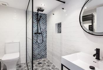 The family bathroom is decorated to a high standard with contemporary tiling and a rainfall shower.