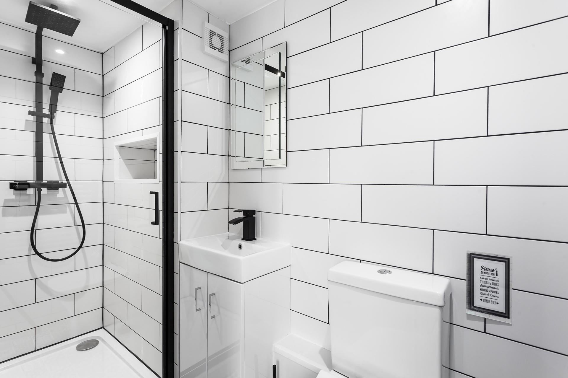 A modern and light en suite with a rainfall shower.