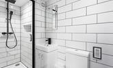 A modern and light en suite with a rainfall shower. - Thumbnail Image