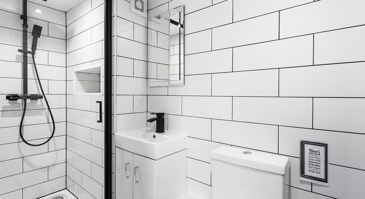 A modern and light en suite with a rainfall shower.