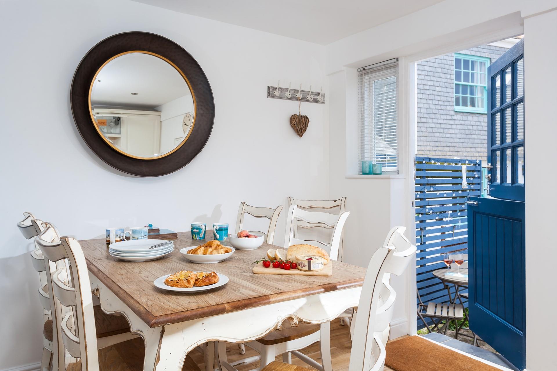 The modern kitchen has natural wood worktops and painted wood cupboards, and bespoke shutters to the window to maximise the light.