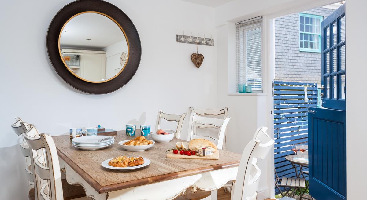 The modern kitchen has natural wood worktops and painted wood cupboards, and bespoke shutters to the window to maximise the light.