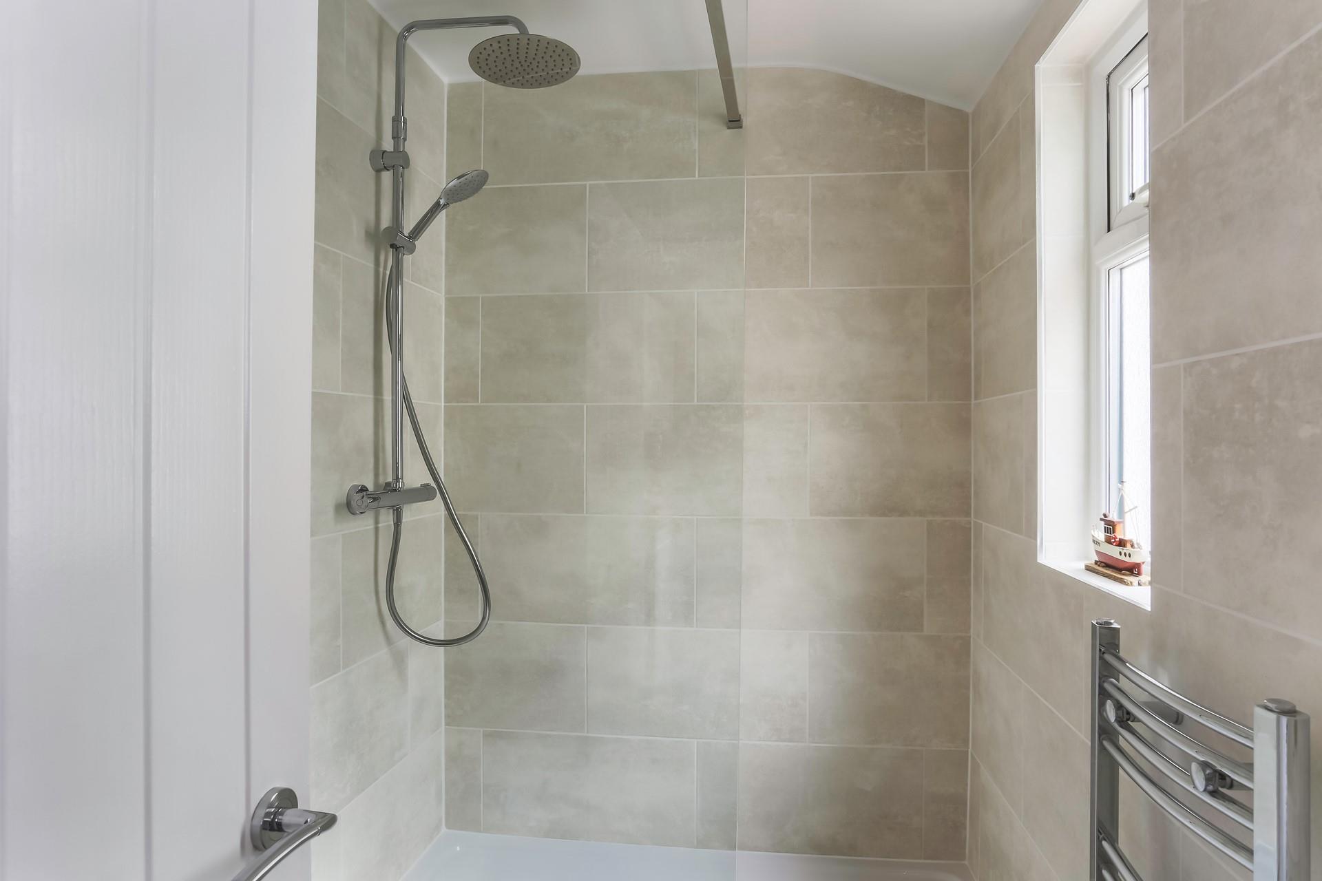 The downstairs family bathroom has a rainfall shower and offers a space to get ready in the morning.