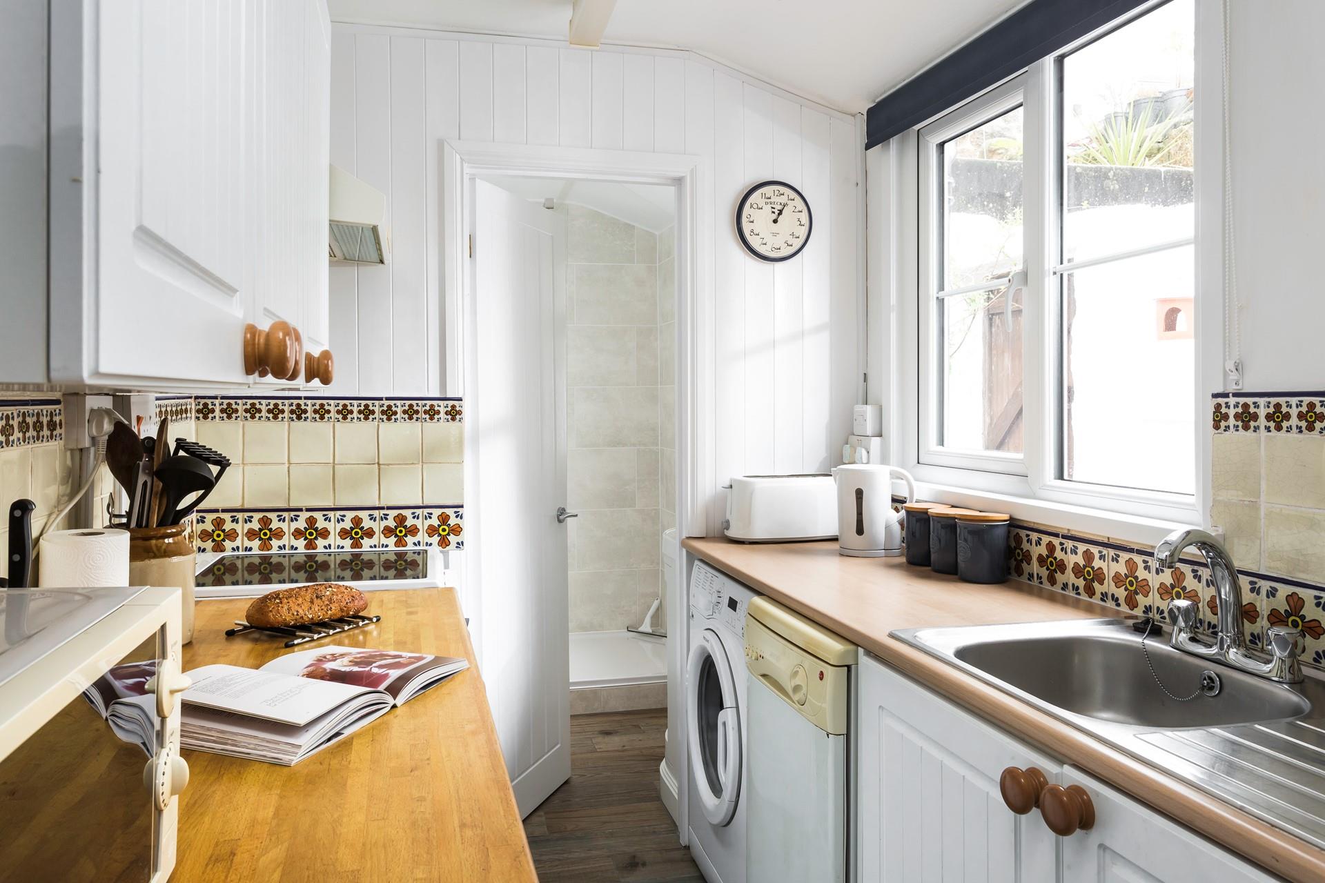 Compact, well-equipped kitchen with door to bathroom.