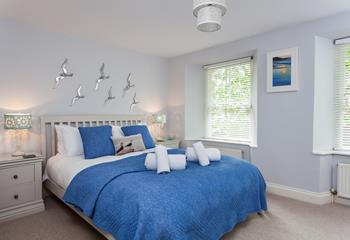 The master bedroom boasts a king size bed and soft linens.