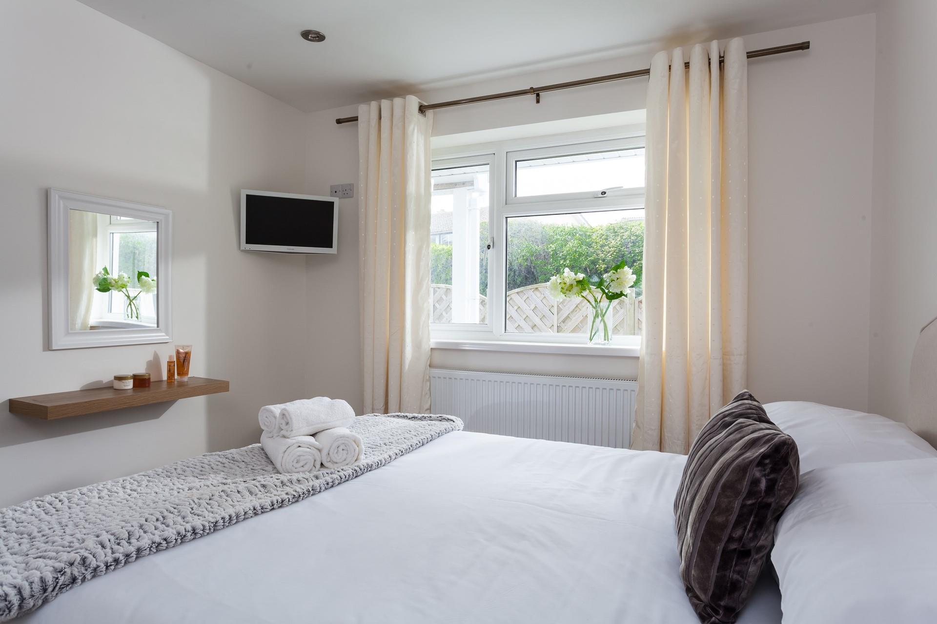 Neutral tones and sumptuously soft accent furnishings create a calming oasis in bedroom 1.