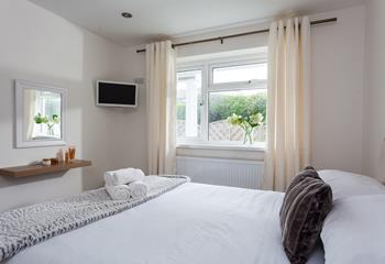 Neutral tones and sumptuously soft accent furnishings create a calming oasis in bedroom 1.