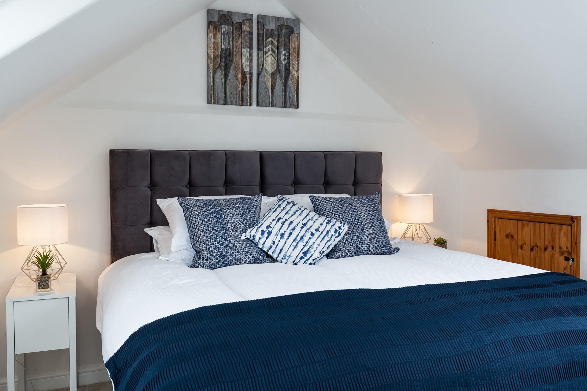 The navy cushions and throw on the super-king bed is the perfect accent colour.