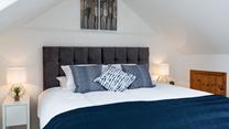 The navy cushions and throw on the super-king bed is the perfect accent colour.
