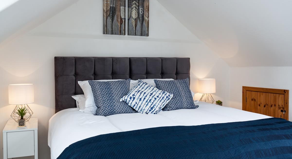 The navy cushions and throw on the super-king bed is the perfect accent colour.