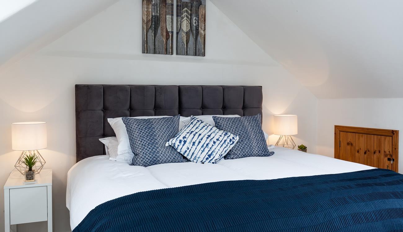 The navy cushions and throw on the super-king bed is the perfect accent colour.