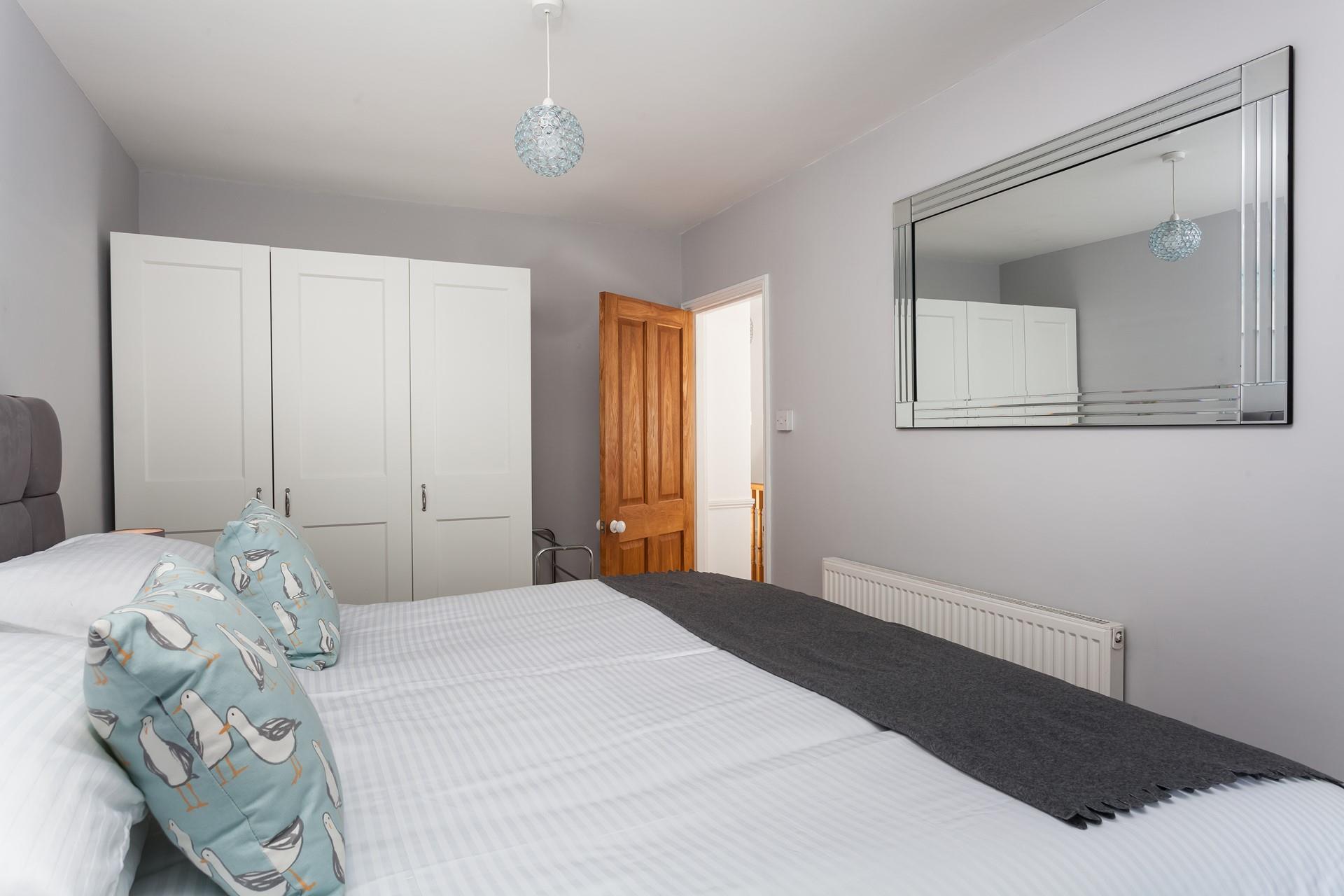 There is extensive wardrobe space in this well-lit room.