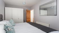 There is extensive wardrobe space in this well-lit room.