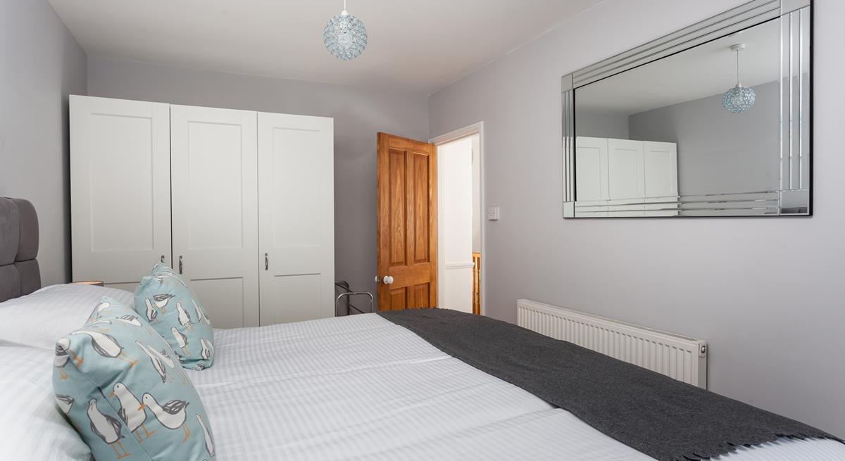 There is extensive wardrobe space in this well-lit room.