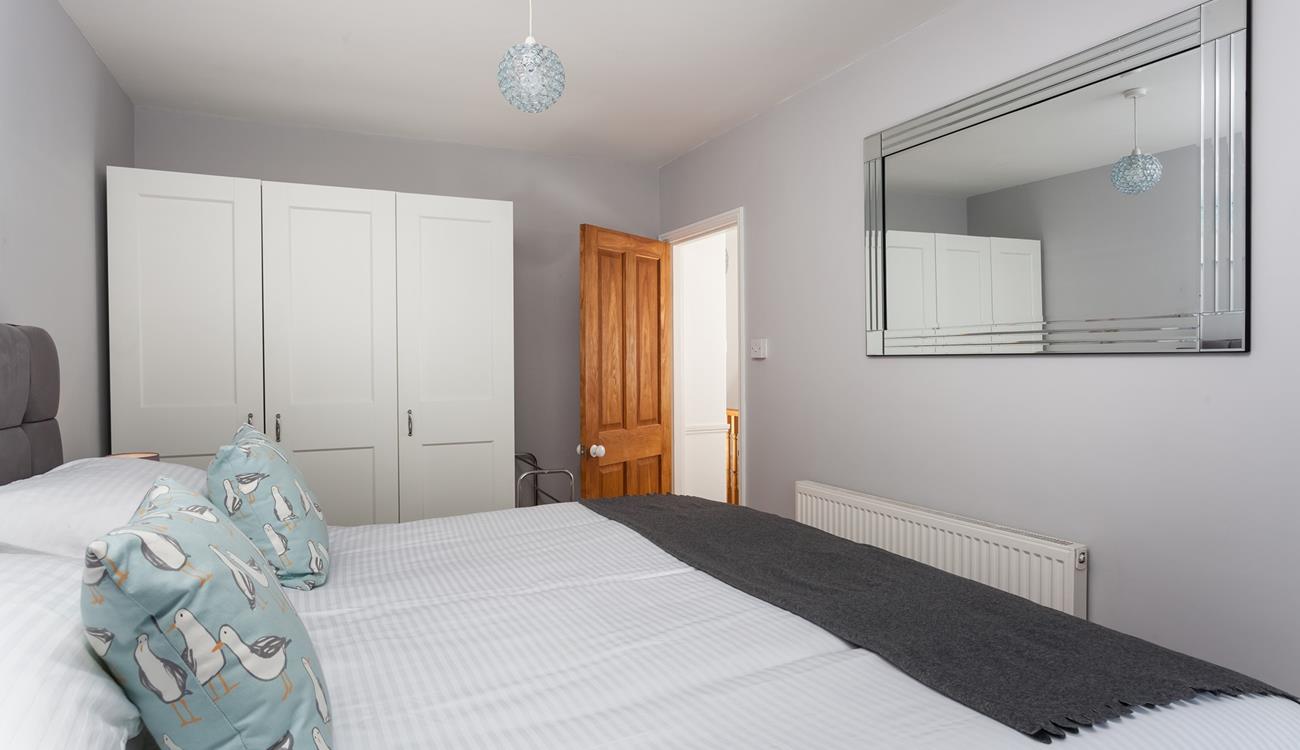 There is extensive wardrobe space in this well-lit room.