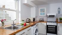The wooden topped kitchen units and contemporary artwork help create a stylish space. 