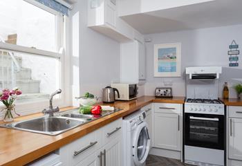 The wooden topped kitchen units and contemporary artwork help create a stylish space. 