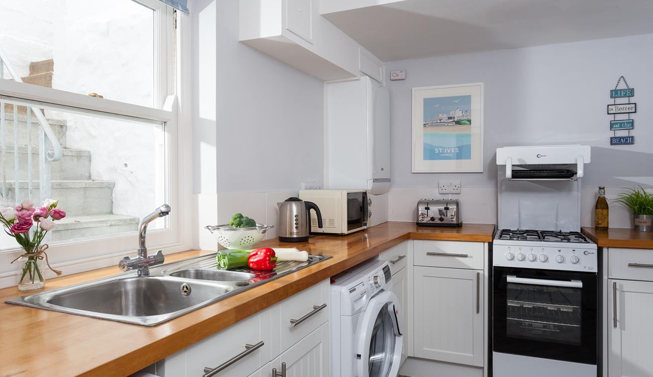 The wooden topped kitchen units and contemporary artwork help create a stylish space. 