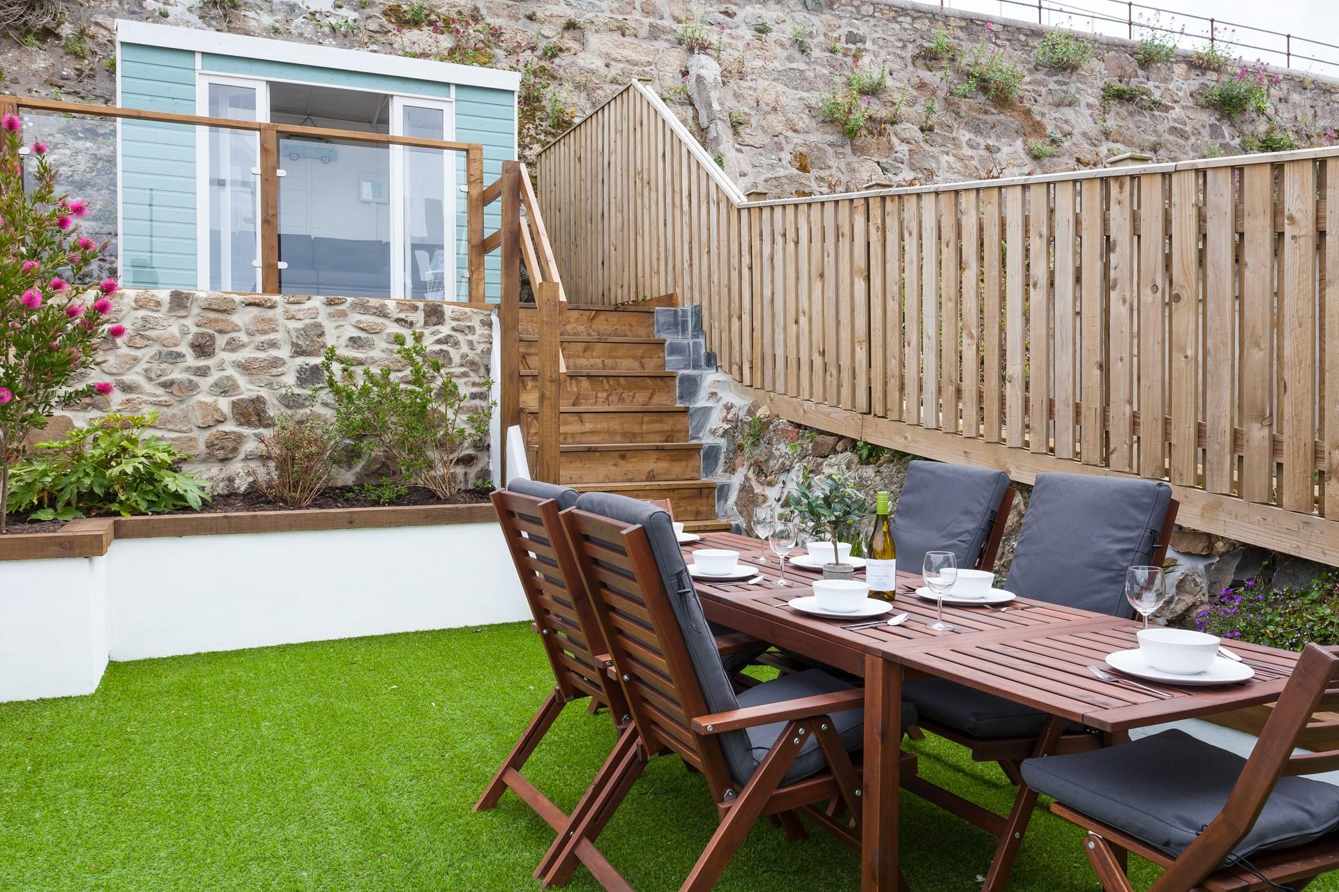 The tiered outside space leads up to a pretty summerhouse, with seating for four.