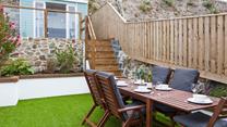 The tiered outside space leads up to a pretty summerhouse, with seating for four.