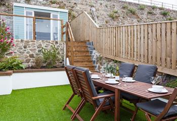 The tiered outside space leads up to a pretty summerhouse, with seating for four.