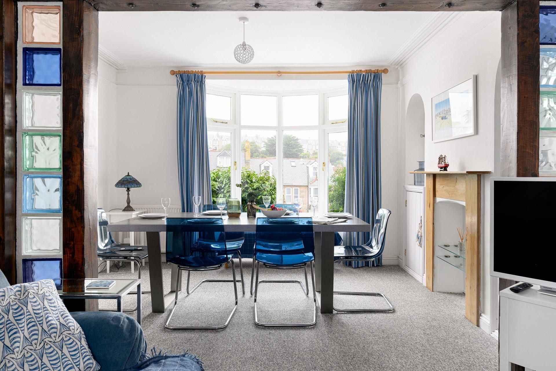Draw back the curtains and let the light flood into this contemporary dining room through the bay window.