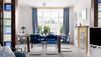 Draw back the curtains and let the light flood into this contemporary dining room through the bay window.